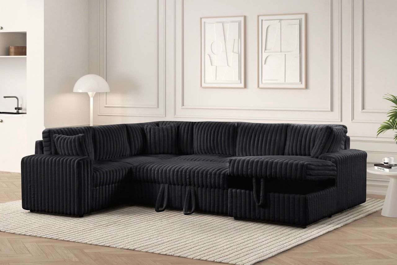 Ryder black corduroy sectional with its pull-out bed extended in a styled living room
